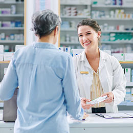 Patient au comptoir d’une officine avec un pharmacien